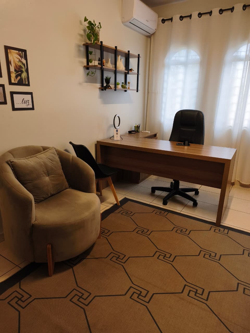 Consultório climatizado com mesa e poltronas